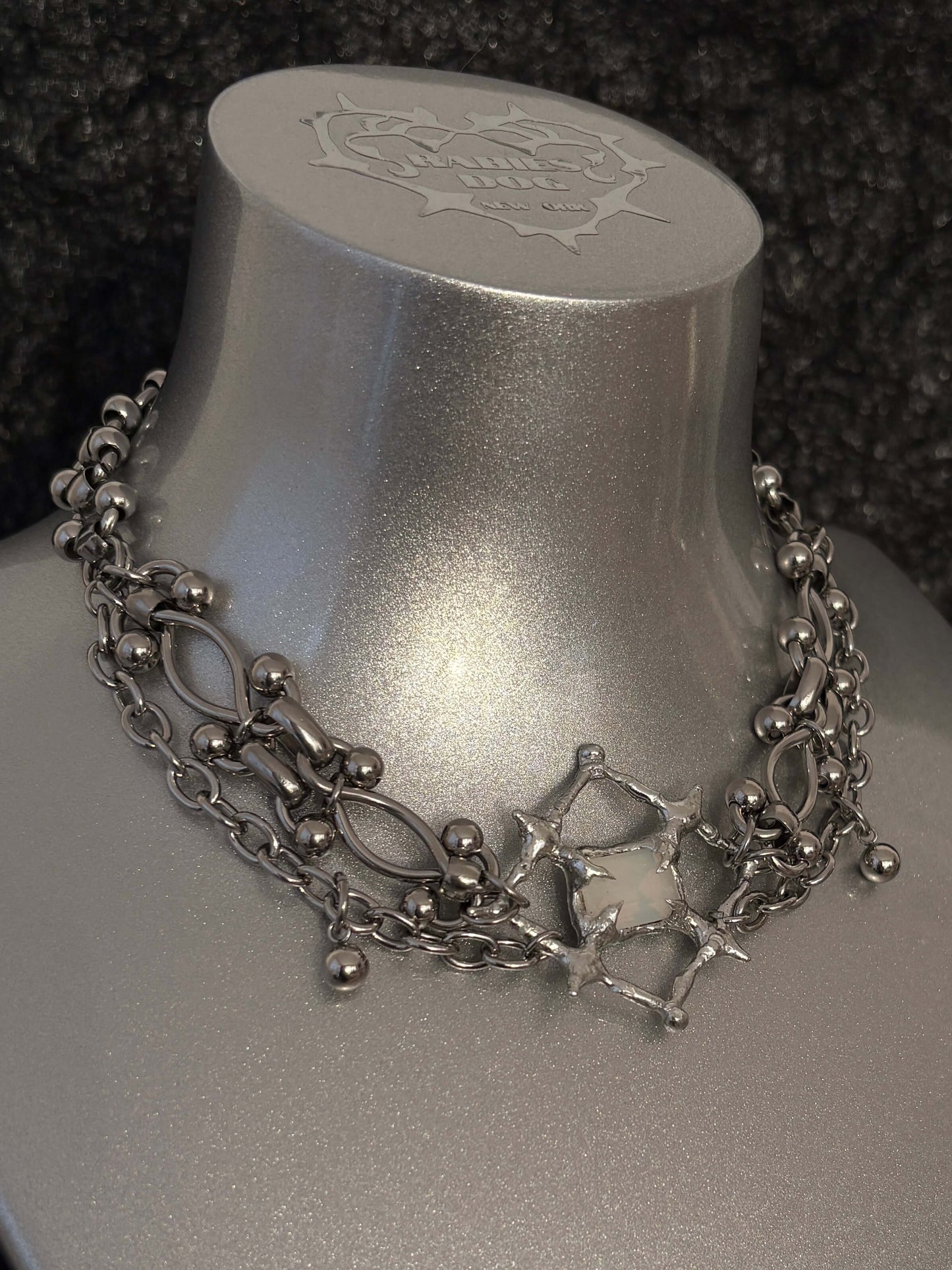 The Angel’s Eye Necklace is a sculptural statement piece inspired by sacred symbolism and watchful, otherworldly forms. Handcrafted by RABIES DOG, it carries a quiet tension between protection and unease