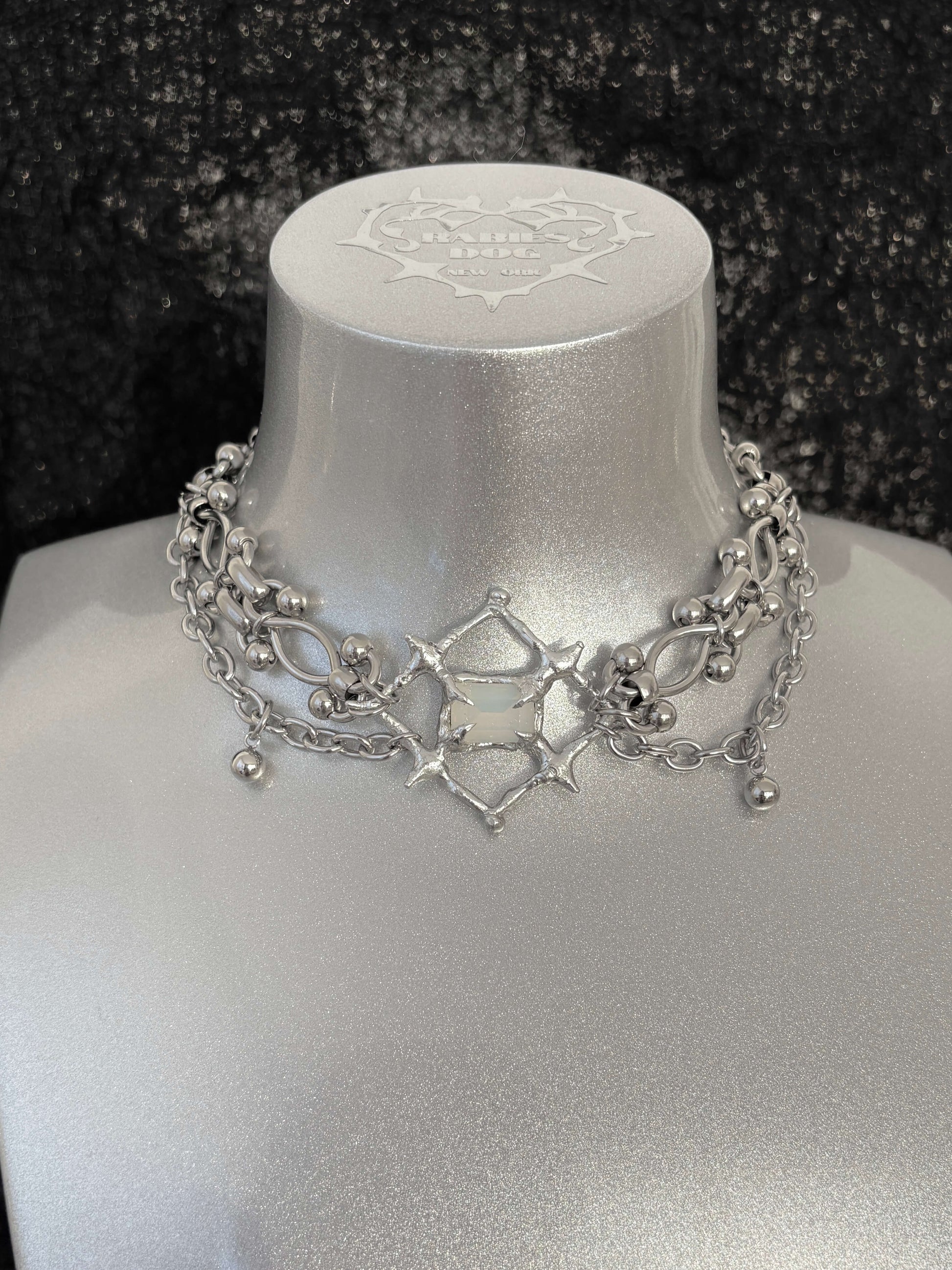 The Angel’s Eye Necklace is a sculptural statement piece inspired by sacred symbolism and watchful, otherworldly forms. Handcrafted by RABIES DOG, it carries a quiet tension between protection and unease